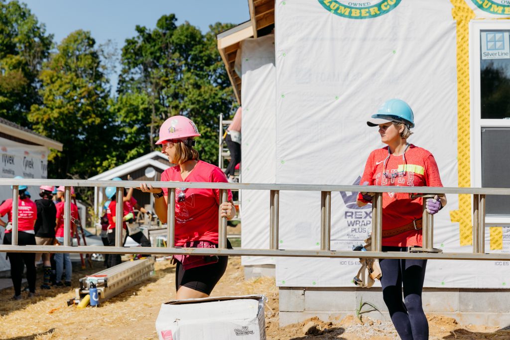 two women carrying a ladder